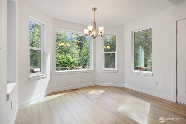 6623 NW Northridge Ln, Bremerton, WA 98312 - unfurnished dining area featuring a chandelier, wood finished floors, and baseboards