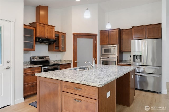 6623 NW Northridge Ln, Bremerton, WA 98312 - kitchen with stainless steel appliances, under cabinet range hood, a sink, light wood-type flooring, and light stone countertops
