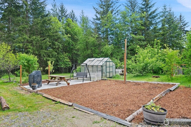 6623 NW Northridge Ln, Bremerton, WA 98312 - view of playground featuring a greenhouse, a patio area, and an outbuilding