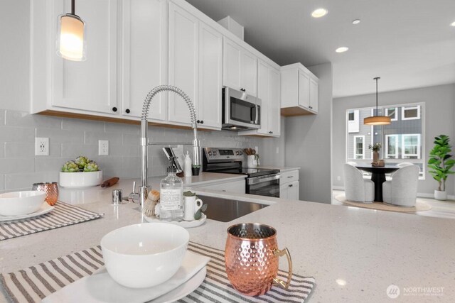 15726 40th Ave W Unit B6, Lynnwood, WA 98087 - kitchen featuring appliances with stainless steel finishes, white cabinetry, decorative backsplash, light stone counters, and recessed lighting