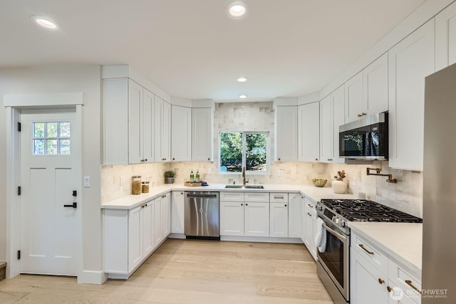 524 27th Ave, Seattle, WA 98122 - kitchen featuring appliances with stainless steel finishes, plenty of natural light, a sink, white cabinetry, and recessed lighting