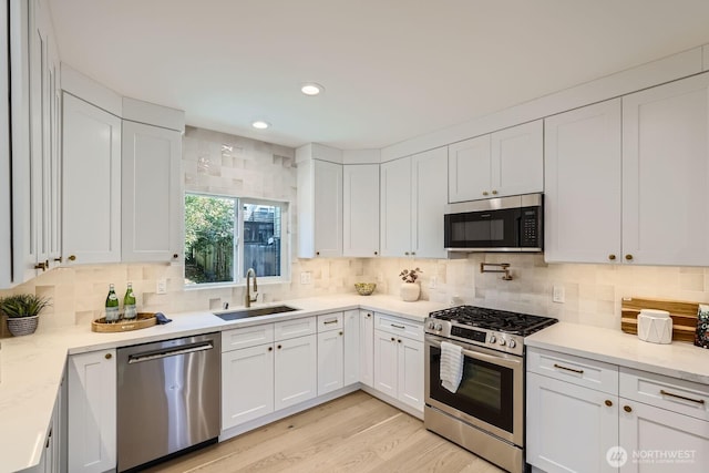 524 27th Ave, Seattle, WA 98122 - kitchen with stainless steel appliances, a sink, white cabinetry, backsplash, and recessed lighting