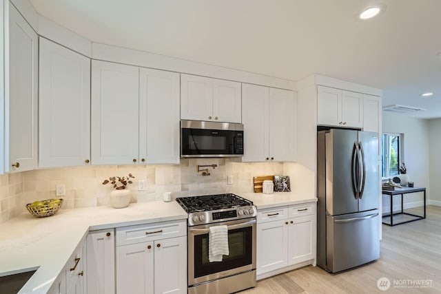 524 27th Ave, Seattle, WA 98122 - kitchen featuring appliances with stainless steel finishes, light wood-style floors, decorative backsplash, white cabinetry, and recessed lighting