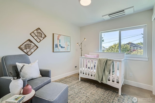 524 27th Ave, Seattle, WA 98122 - bedroom featuring baseboards, wood finished floors, and a crib