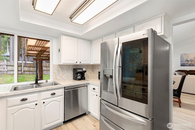 5371 Pineridge Dr NE, Bremerton, WA 98311 - kitchen with appliances with stainless steel finishes, a sink, a tray ceiling, light wood-style flooring, and white cabinetry