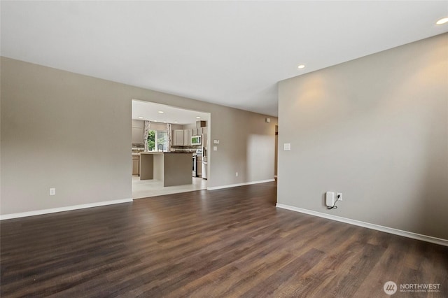 23588 Cooma Pl, Mount Vernon, WA 98274 - unfurnished living room featuring wood finished floors, baseboards, and recessed lighting