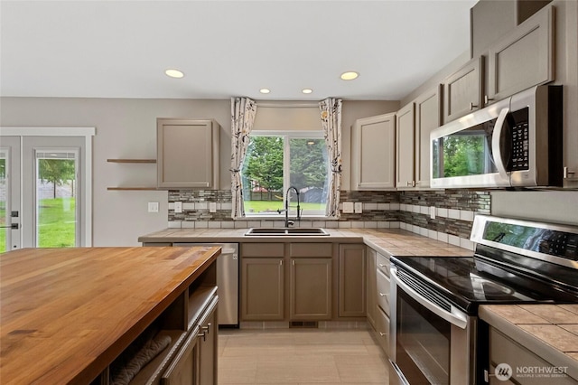 23588 Cooma Pl, Mount Vernon, WA 98274 - kitchen with appliances with stainless steel finishes, a sink, tile counters, open shelves, and tasteful backsplash