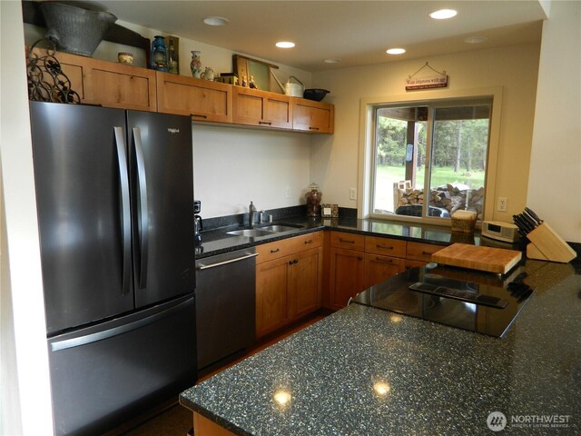 302 Summer Rd, Tonasket, WA 98855 - kitchen with freestanding refrigerator, stainless steel dishwasher, a sink, brown cabinetry, and dark stone counters