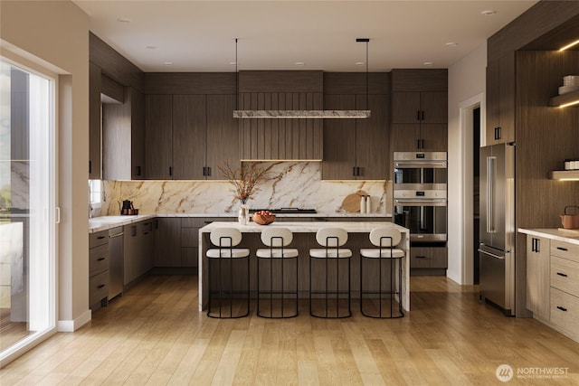 1301 Leighton St, Blaine, WA 98230 - kitchen with appliances with stainless steel finishes, light countertops, decorative backsplash, and light wood-type flooring