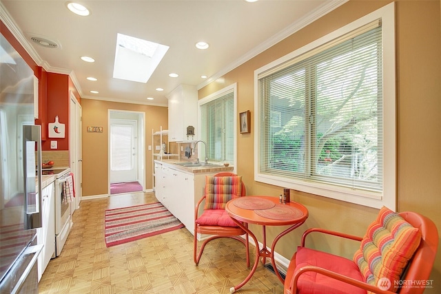 614 NW 126th Pl, Seattle, WA 98177 - kitchen featuring white electric stove, a skylight, light countertops, crown molding, and healthy amount of natural light