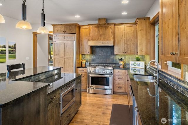 950 Coal Mine Way, Cle Elum, WA 98922 - kitchen featuring built in appliances, a sink, premium range hood, light wood-style flooring, and tasteful backsplash