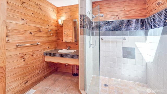 152 Richwood Ln, Lopez Island, WA 98261 - bathroom featuring a tile shower, tile patterned flooring, a sink, and wooden walls