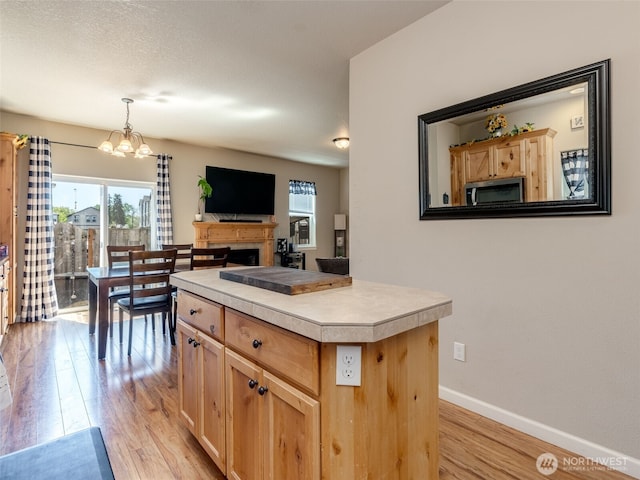2962 26th Ave, Forest Grove, OR 97116 - kitchen featuring stainless steel microwave, light wood-type flooring, light countertops, baseboards, and a chandelier