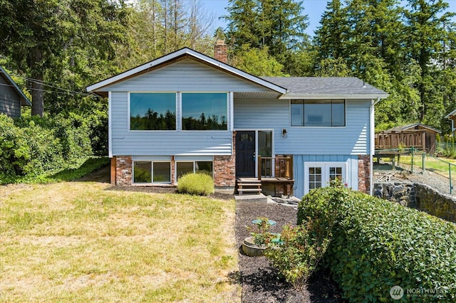 13371 Eagle St, Anacortes, WA 98221 - rear view of property featuring a yard, a chimney, and roof with shingles