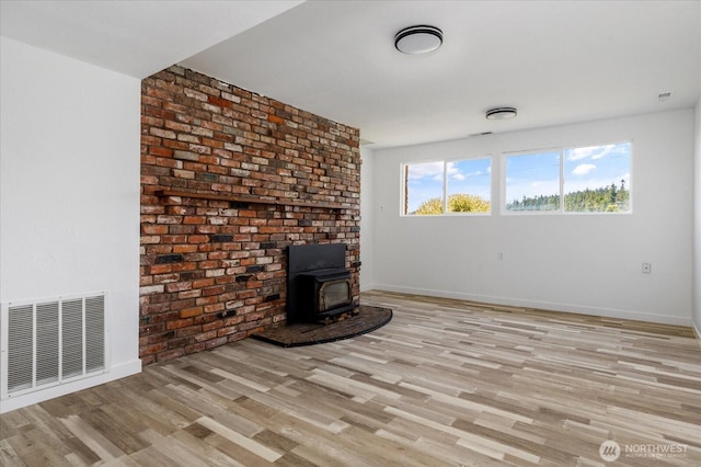 13371 Eagle St, Anacortes, WA 98221 - unfurnished living room with a wood stove, light wood finished floors, and baseboards
