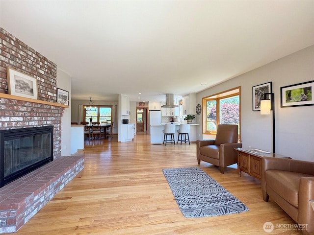 22 E Bedinger Rd, Sequim, WA 98382 - living area with light wood-style floors, healthy amount of natural light, and a brick fireplace