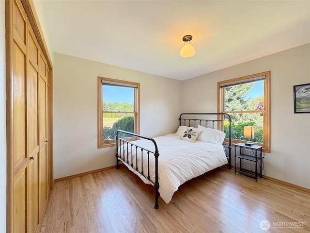 22 E Bedinger Rd, Sequim, WA 98382 - bedroom featuring multiple windows, light wood finished floors, and baseboards
