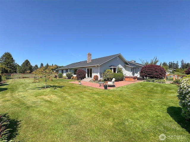 22 E Bedinger Rd, Sequim, WA 98382 - back of property featuring a chimney, a patio area, and a hot tub