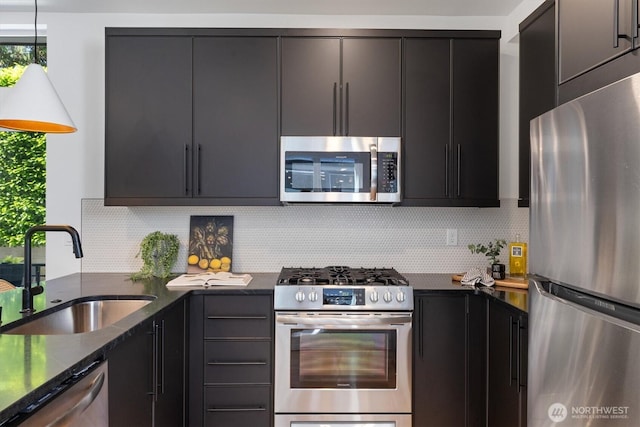 1134 32nd Ave E Unit B, Seattle, WA 98112 - kitchen featuring stainless steel appliances, a sink, backsplash, dark stone countertops, and dark cabinetry