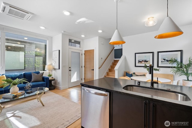 1134 32nd Ave E Unit B, Seattle, WA 98112 - kitchen with dishwasher, a sink, dark countertops, light wood-type flooring, and hanging light fixtures