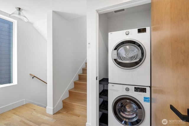 1134 32nd Ave E Unit B, Seattle, WA 98112 - laundry room featuring stacked washer / dryer, wood finished floors, and baseboards