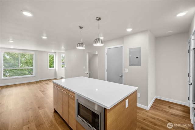 5915 Fauntleroy Way SW Unit C, Seattle, WA 98136 - kitchen featuring stainless steel microwave, electric panel, a center island, light wood-style floors, and baseboards