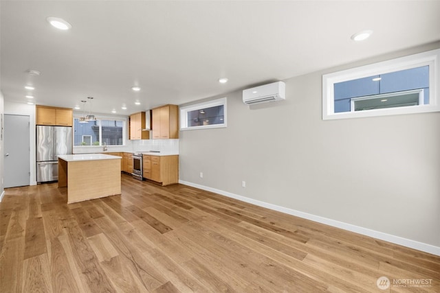 5915 Fauntleroy Way SW Unit C, Seattle, WA 98136 - kitchen featuring appliances with stainless steel finishes, a wall mounted AC, a center island, light countertops, and light wood-type flooring