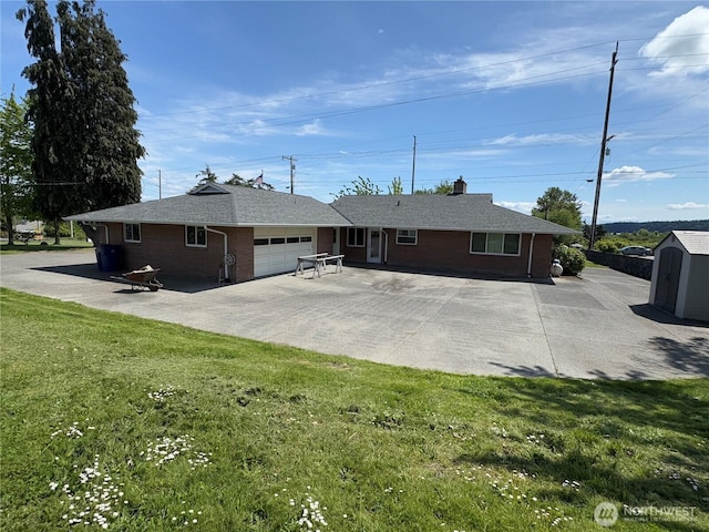 851 Heichel Rd, Camano Island, WA 98282 - rear view of house featuring a garage, brick siding, a lawn, a chimney, and driveway
