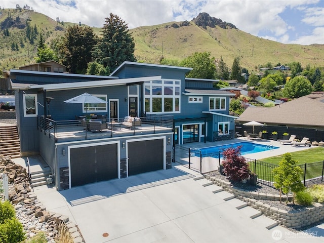 1425 Appleridge St, Wenatchee, WA 98801 - rear view of property featuring an attached garage, driveway, a mountain view, and a balcony