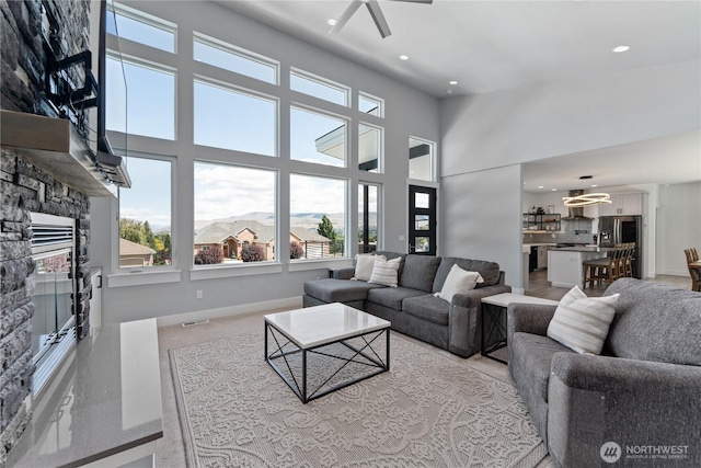 1425 Appleridge St, Wenatchee, WA 98801 - living room featuring a stone fireplace, recessed lighting, baseboards, ceiling fan, and a chandelier