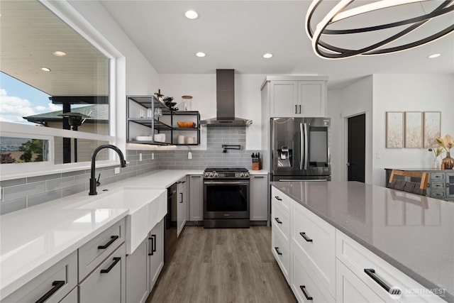 1425 Appleridge St, Wenatchee, WA 98801 - kitchen with appliances with stainless steel finishes, wall chimney exhaust hood, decorative backsplash, wood finished floors, and recessed lighting
