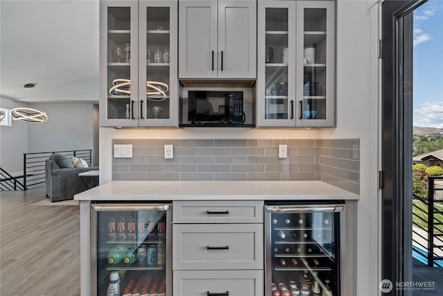 1425 Appleridge St, Wenatchee, WA 98801 - bar featuring wine cooler, black microwave, backsplash, and light wood-style flooring