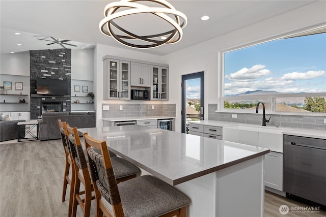 1425 Appleridge St, Wenatchee, WA 98801 - kitchen featuring stainless steel dishwasher, black microwave, a large fireplace, tasteful backsplash, and recessed lighting
