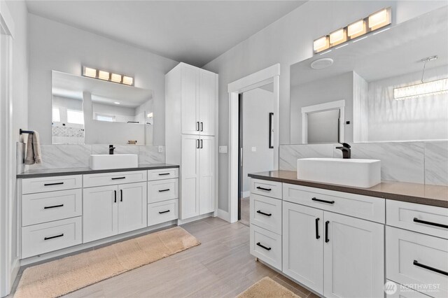 1425 Appleridge St, Wenatchee, WA 98801 - bathroom featuring two vanities, wood finished floors, tasteful backsplash, and a shower