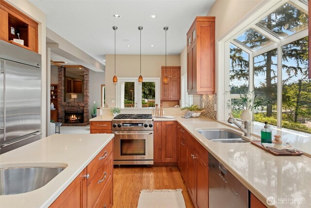1805 179th Pl NE, Bellevue, WA 98008 - kitchen featuring appliances with stainless steel finishes, a sink, light countertops, light wood finished floors, and brown cabinets