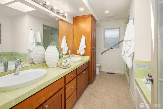 1211 6th Pl S, Edmonds, WA 98020 - bathroom with double vanity, a bath, toilet, tile patterned floors, and baseboards
