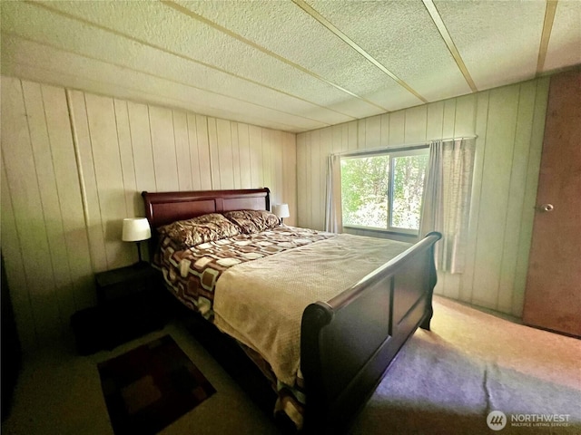 1911 324th, Long Beach, WA 98631 - bedroom with carpet floors, wooden walls, and a textured ceiling