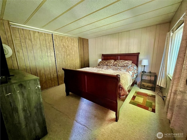 1911 324th, Long Beach, WA 98631 - carpeted bedroom featuring wooden walls and a textured ceiling