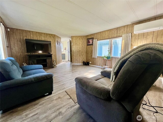 1911 324th, Long Beach, WA 98631 - living room with wood walls, an AC wall unit, wood finished floors, and baseboards