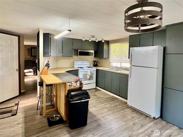 1911 324th, Long Beach, WA 98631 - kitchen with white appliances, a sink, light wood-type flooring, and light countertops