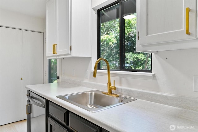 5410 240th St SW, Mountlake Terrace, WA 98043 - kitchen featuring stainless steel dishwasher, white cabinetry, light countertops, and plenty of natural light