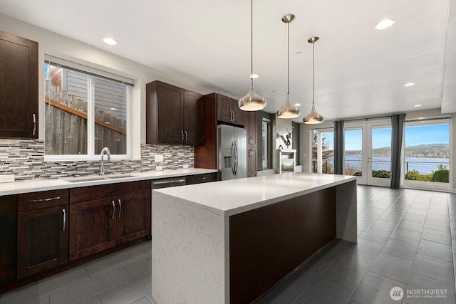 10445 Dixon Dr S, Seattle, WA 98178 - kitchen featuring a sink, stainless steel fridge with ice dispenser, tasteful backsplash, dark brown cabinetry, and tile patterned floors