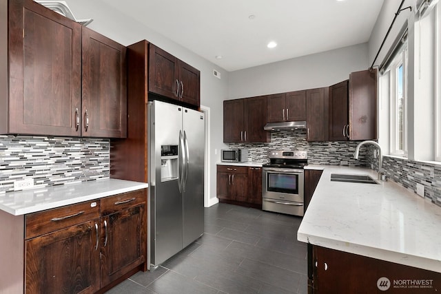 10445 Dixon Dr S, Seattle, WA 98178 - kitchen with appliances with stainless steel finishes, a sink, under cabinet range hood, backsplash, and dark brown cabinets