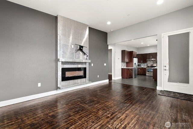 10445 Dixon Dr S, Seattle, WA 98178 - unfurnished living room featuring dark wood-style flooring, a large fireplace, recessed lighting, and baseboards