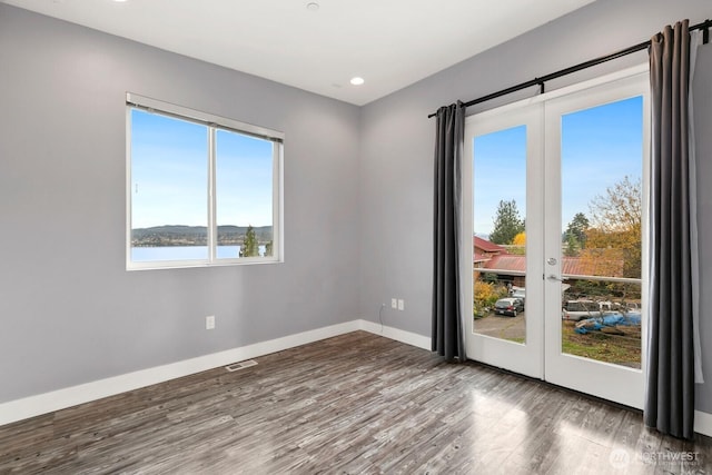 10445 Dixon Dr S, Seattle, WA 98178 - unfurnished room with wood finished floors, baseboards, recessed lighting, and a water view
