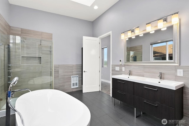 10445 Dixon Dr S, Seattle, WA 98178 - bathroom with tile walls, a soaking tub, a stall shower, double vanity, and recessed lighting