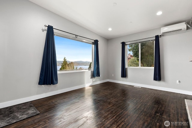 10445 Dixon Dr S, Seattle, WA 98178 - unfurnished room featuring an AC wall unit, wood finished floors, baseboards, and recessed lighting
