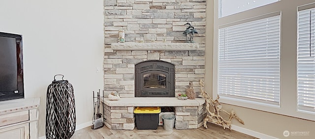 3060 NE Wheeler St, Poulsbo, WA 98370 - detailed view of baseboards, wood finished floors, and a stone fireplace