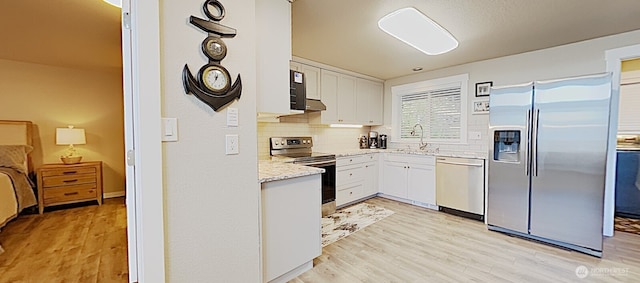 3060 NE Wheeler St, Poulsbo, WA 98370 - kitchen featuring appliances with stainless steel finishes, a sink, light wood-type flooring, and decorative backsplash