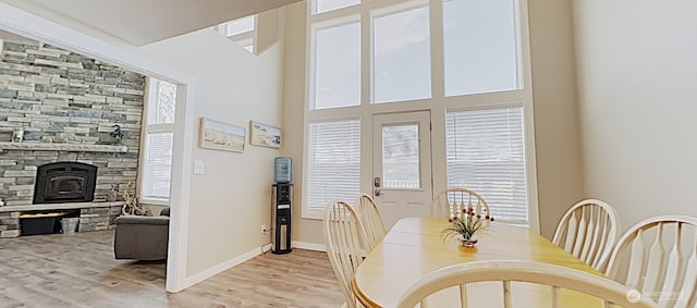3060 NE Wheeler St, Poulsbo, WA 98370 - dining area with light wood-style flooring, a stone fireplace, and baseboards